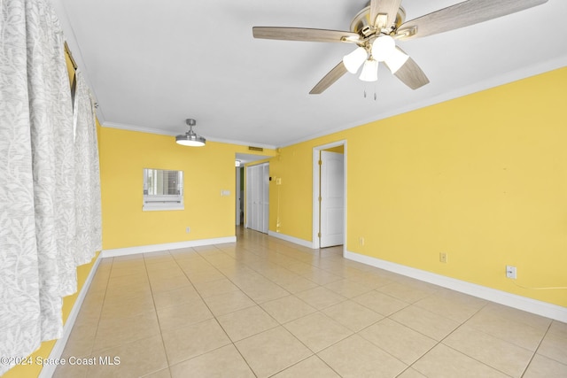 tiled empty room featuring ceiling fan and crown molding