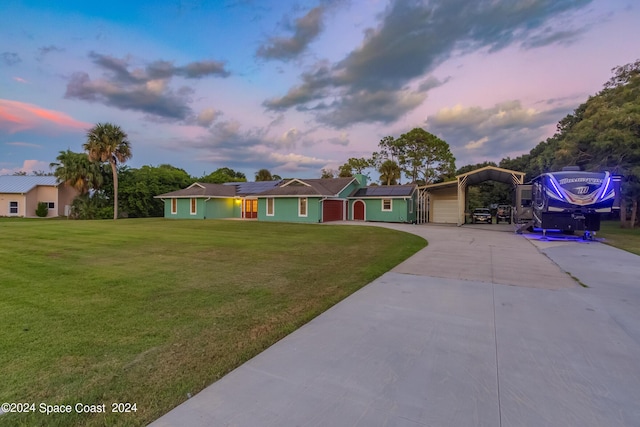 ranch-style house with a yard and solar panels