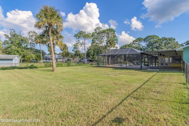 view of yard featuring glass enclosure and a pool