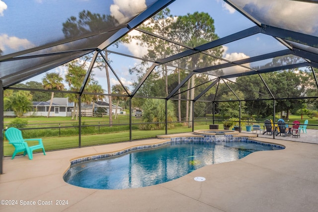 view of pool with a lawn, glass enclosure, and a patio