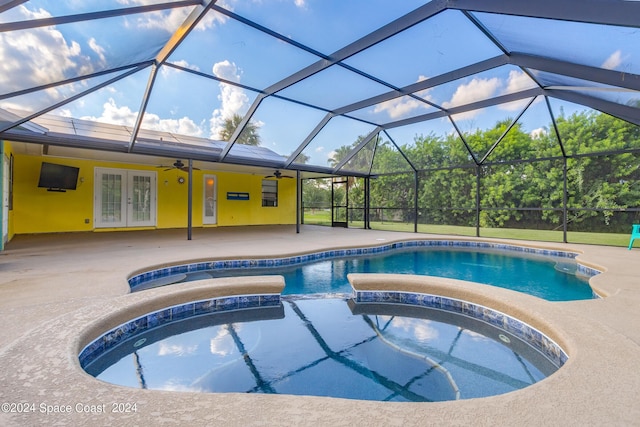 view of pool featuring an in ground hot tub, french doors, glass enclosure, and a patio area