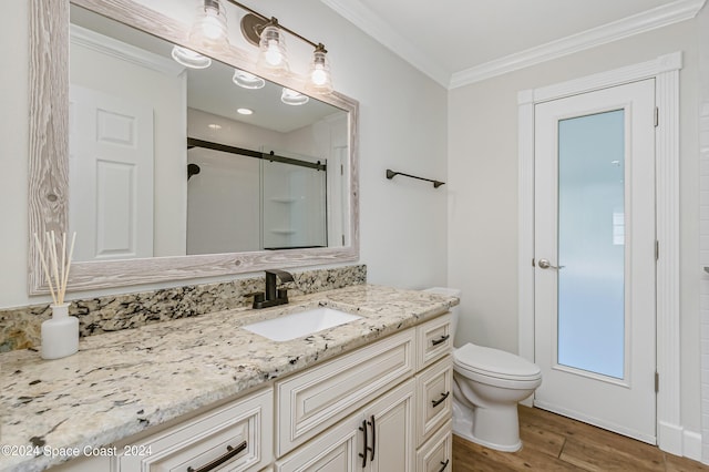 bathroom featuring an enclosed shower, ornamental molding, vanity, wood-type flooring, and toilet