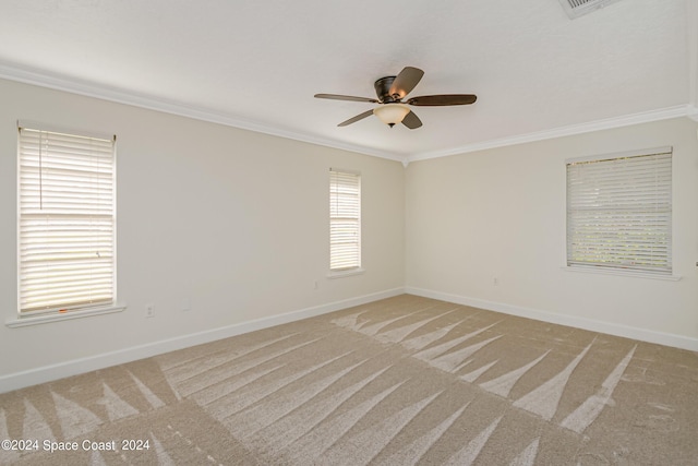 spare room featuring carpet flooring, crown molding, ceiling fan, and a healthy amount of sunlight