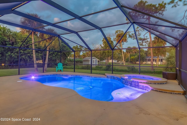 pool at dusk featuring a patio area, a lanai, and a yard