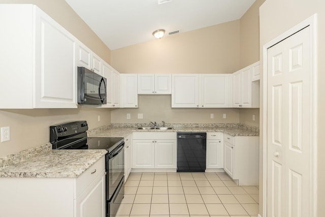 867 S Patrick Dr, Satellite Beach, FL 32937 - kitchen with black appliances, lofted ceiling, white cabinets, and light tile patterned floors