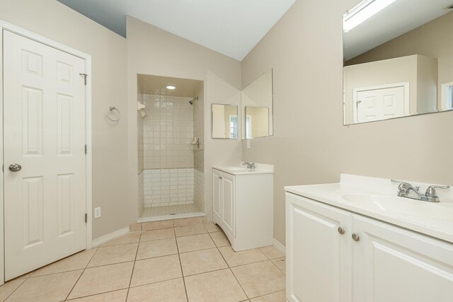 867 S Patrick Dr, Satellite Beach, FL 32937 - bathroom featuring tiled shower, tile patterned flooring, two vanities, and lofted ceiling