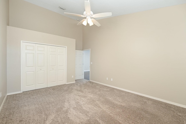 867 S Patrick Dr, Satellite Beach, FL 32937 - unfurnished bedroom featuring carpet flooring, high vaulted ceiling, a closet, and a ceiling fan