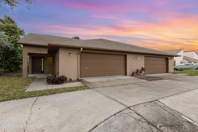 867 S Patrick Dr, Satellite Beach, FL 32937 - view of front of house featuring stucco siding, driveway, and an attached garage