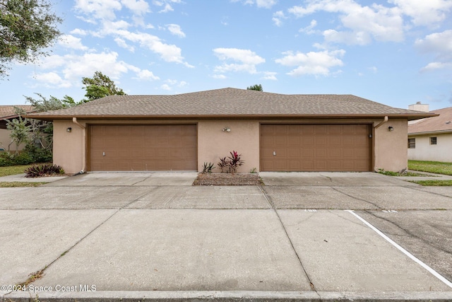 867 S Patrick Dr, Satellite Beach, FL 32937 - view of front of house featuring stucco siding, driveway, and a garage