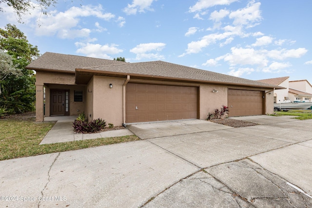 867 S Patrick Dr, Satellite Beach, FL 32937 - view of front of property featuring driveway, stucco siding, and an attached garage