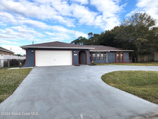 single story home featuring a garage and a front yard