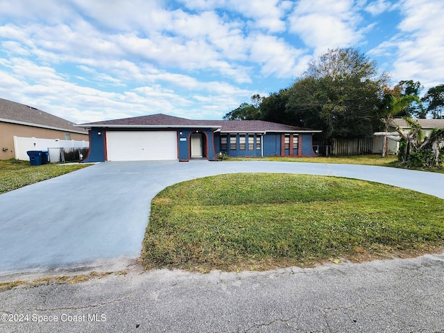 single story home featuring a garage and a front lawn