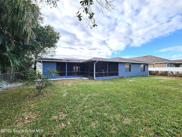 back of property featuring a yard and a sunroom