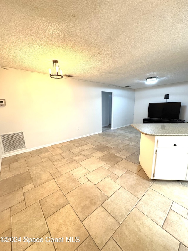 kitchen featuring white cabinets and a textured ceiling