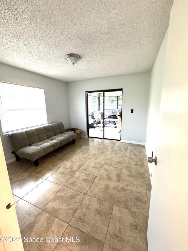 unfurnished living room featuring light tile patterned floors and a textured ceiling