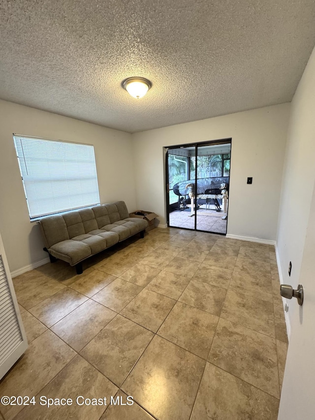 unfurnished living room with light tile patterned floors and a textured ceiling