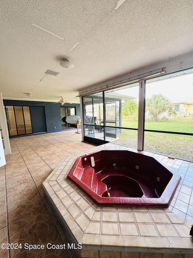 interior space featuring a tub and a textured ceiling