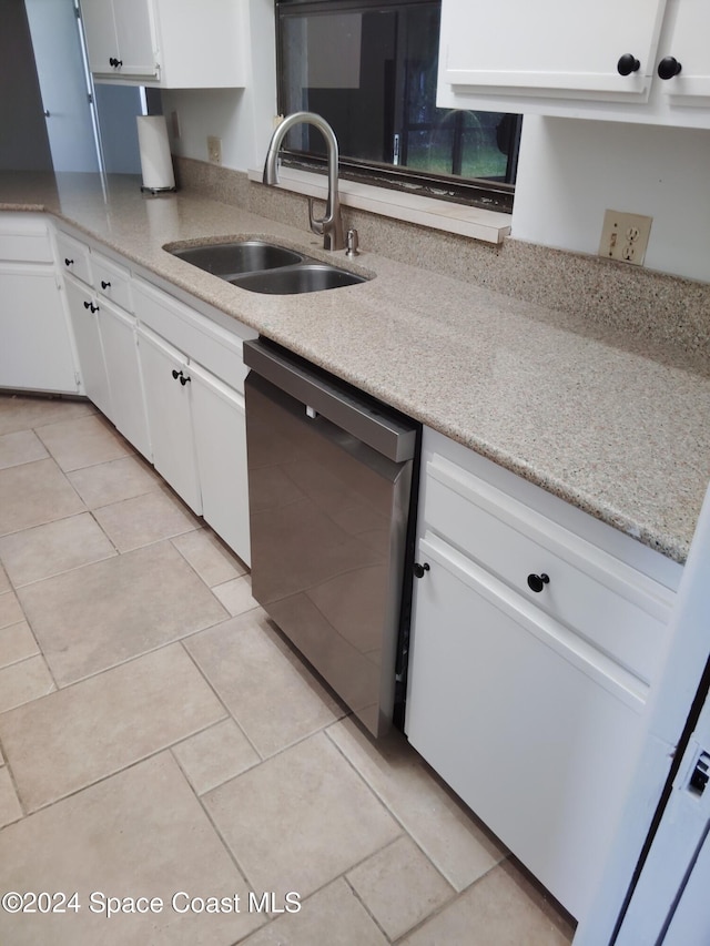 kitchen featuring sink, white cabinetry, black dishwasher, light stone countertops, and light tile patterned flooring