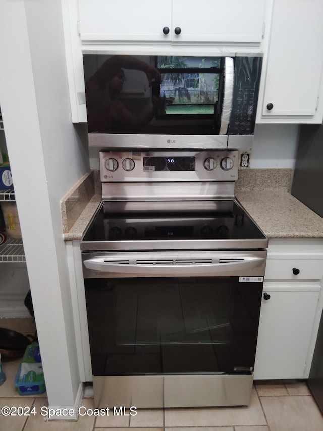 kitchen with white cabinetry, stainless steel appliances, and light tile patterned flooring