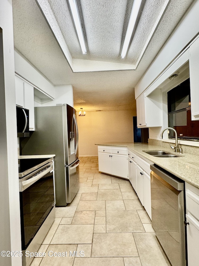 kitchen with sink, white cabinetry, a textured ceiling, light tile patterned floors, and stainless steel appliances