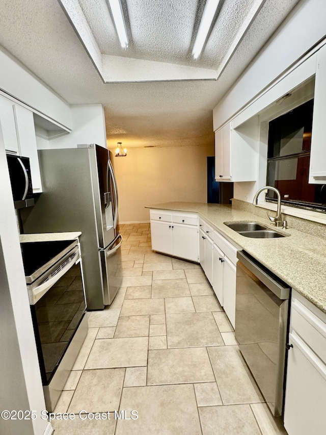 kitchen with stainless steel appliances, sink, a textured ceiling, and white cabinets