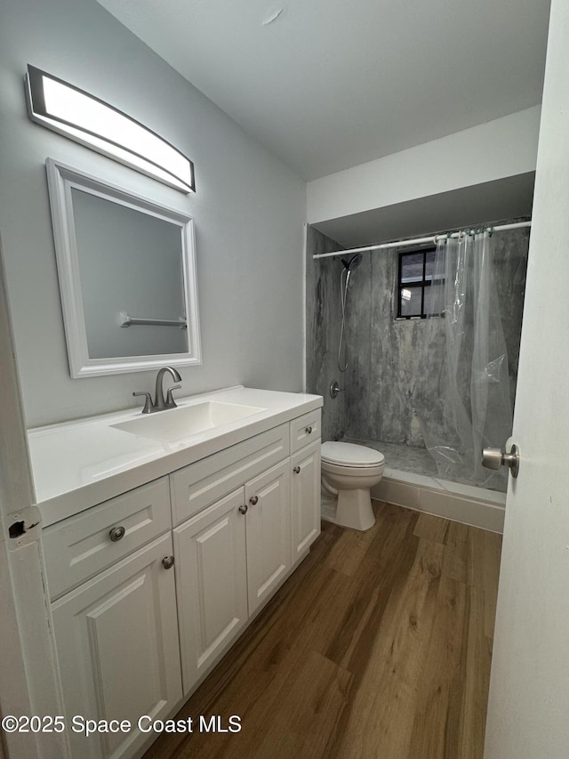 bathroom featuring hardwood / wood-style flooring, vanity, toilet, and a shower with curtain