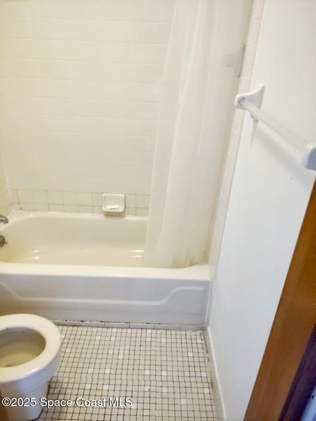 bathroom featuring shower / bathtub combination with curtain, tile patterned floors, and toilet