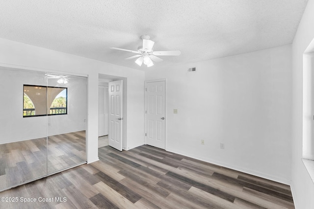 unfurnished room featuring dark hardwood / wood-style floors, a textured ceiling, and ceiling fan