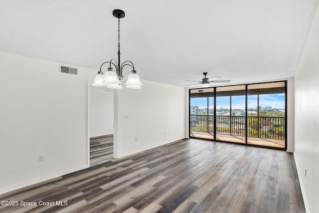 unfurnished dining area featuring expansive windows, ceiling fan with notable chandelier, hardwood / wood-style floors, and a textured ceiling