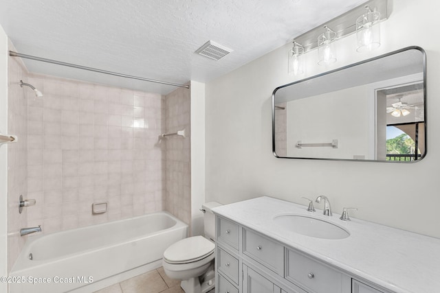 full bathroom with tiled shower / bath combo, vanity, toilet, tile patterned floors, and a textured ceiling