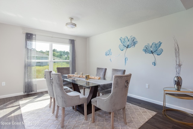 dining room with hardwood / wood-style floors and a textured ceiling