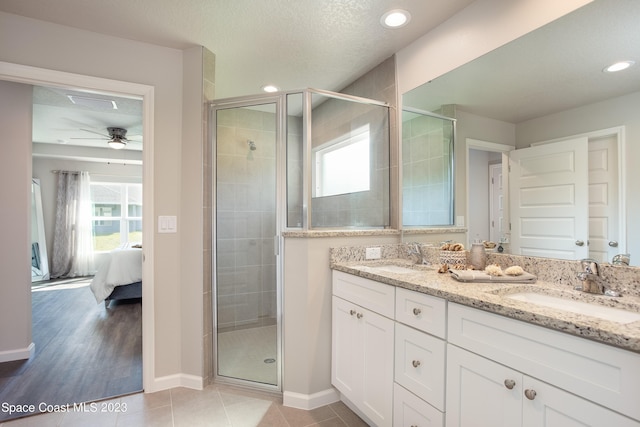 bathroom featuring ceiling fan, plenty of natural light, wood-type flooring, and a textured ceiling