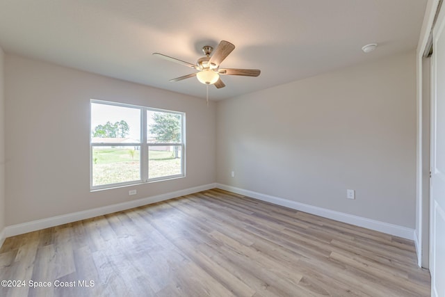 empty room with ceiling fan and light hardwood / wood-style flooring