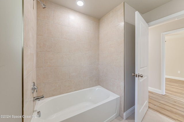 bathroom featuring hardwood / wood-style flooring and tiled shower / bath