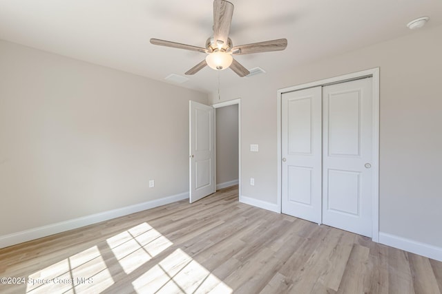 unfurnished bedroom featuring ceiling fan, light hardwood / wood-style floors, and a closet