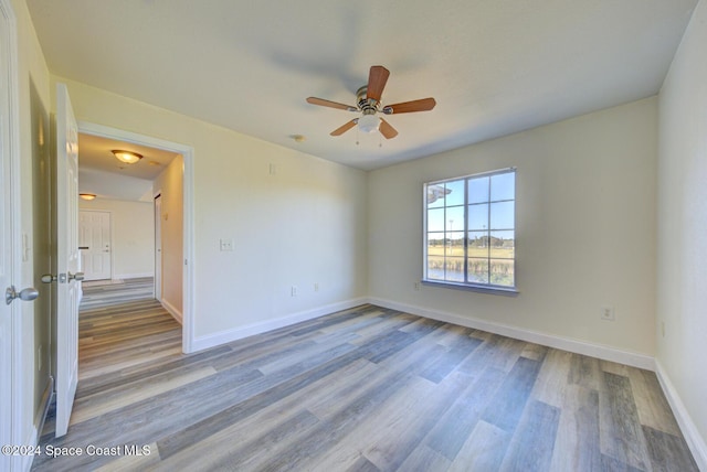 empty room with ceiling fan and hardwood / wood-style flooring