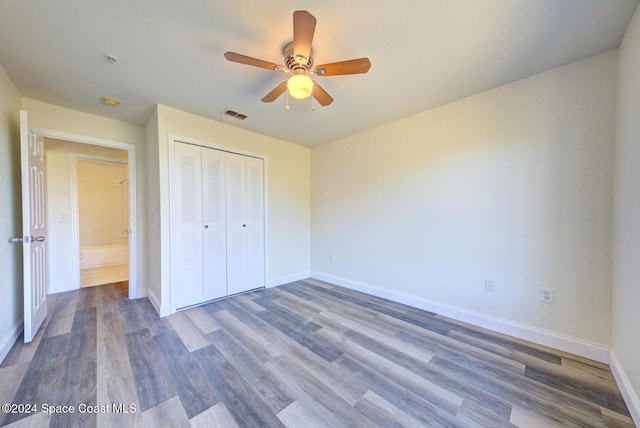 unfurnished bedroom with a closet, hardwood / wood-style flooring, and ceiling fan