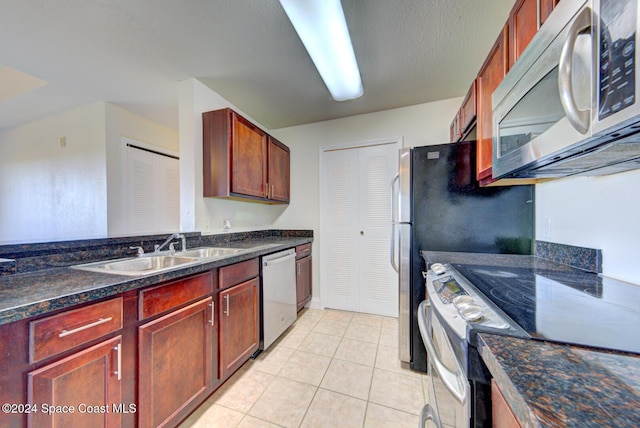 kitchen with light tile patterned flooring, stainless steel appliances, and sink