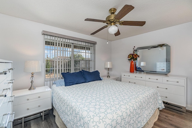 bedroom featuring ceiling fan, dark hardwood / wood-style floors, and a textured ceiling