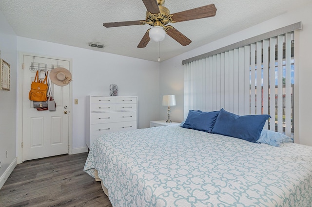 bedroom with dark hardwood / wood-style floors, ceiling fan, a textured ceiling, and a closet