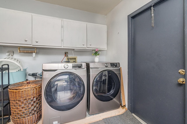 laundry room with washer and dryer and cabinets