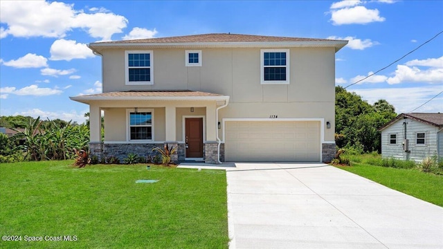 view of front of home featuring covered porch, a garage, and a front yard