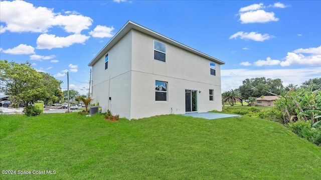 back of property with a lawn and central air condition unit