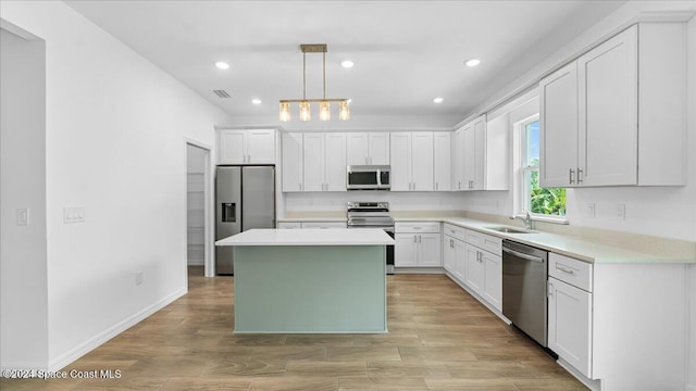 kitchen with white cabinetry, a center island, pendant lighting, and appliances with stainless steel finishes