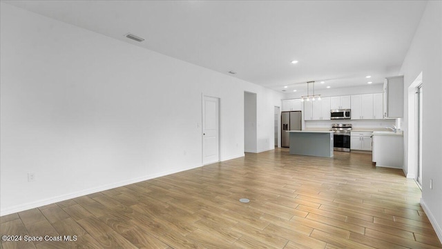 unfurnished living room with light hardwood / wood-style floors and sink