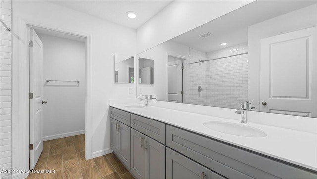 bathroom with vanity, wood-type flooring, and tiled shower