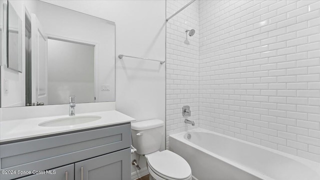 full bathroom featuring toilet, vanity, and tiled shower / bath