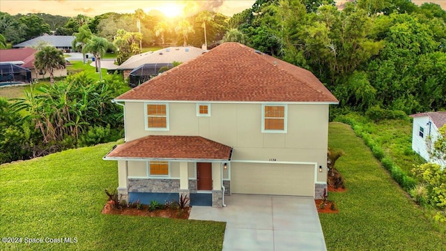 view of front of property with a yard and a garage