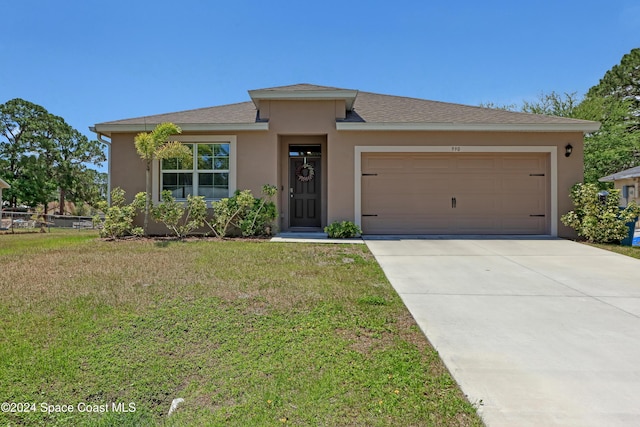 view of front of home with a garage and a front lawn