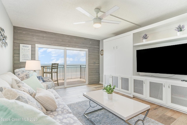 650 N Atlantic Ave # 706, Cocoa Beach, FL 32931 - living area featuring wood walls, a ceiling fan, and light wood finished floors